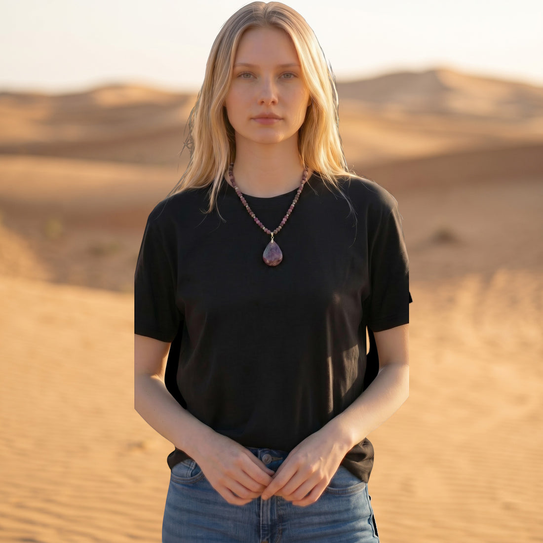 Niz & Aly teardrop purple charoite pendant necklace with multi-colored beads worn by a woman in a desert setting.