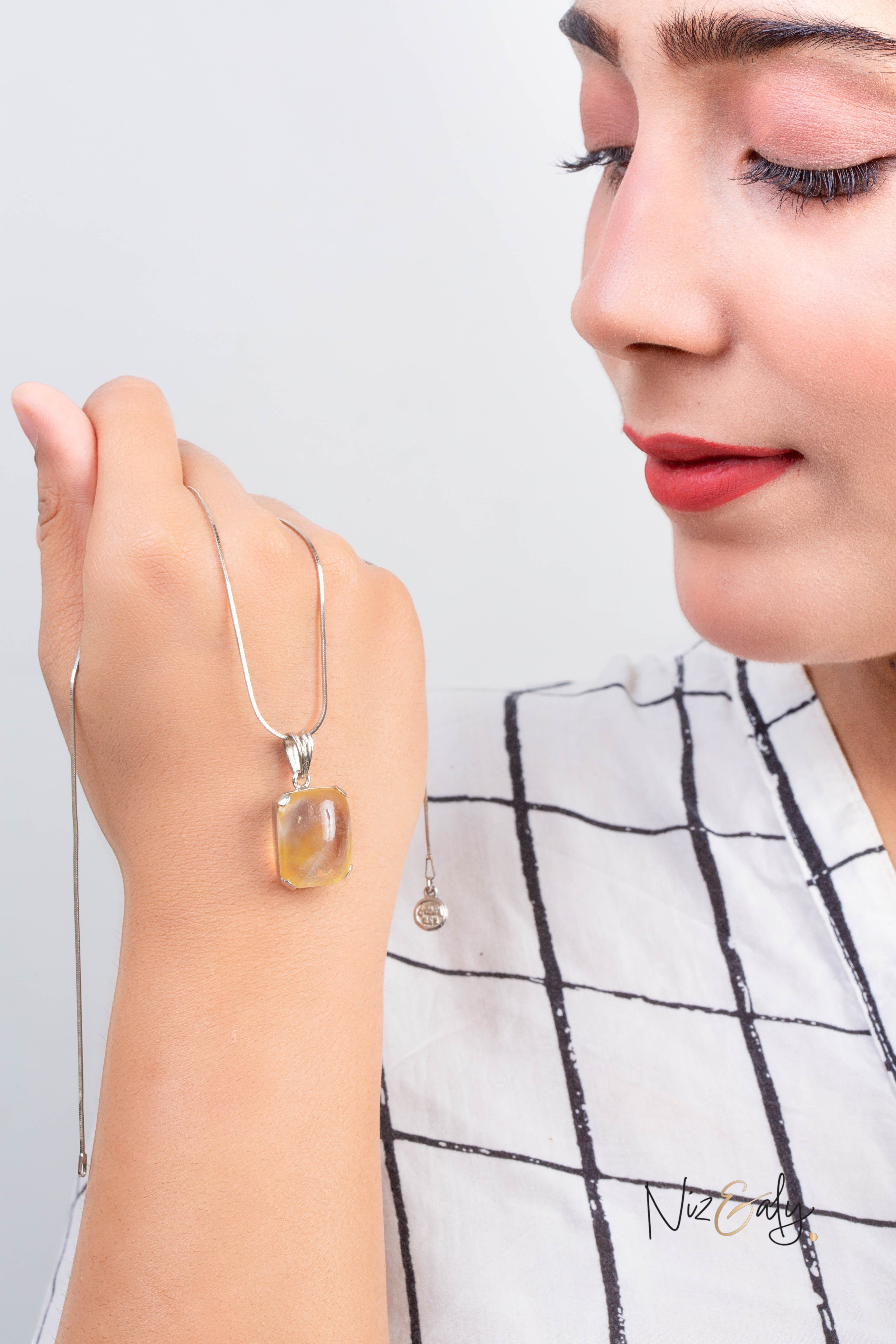 Niz & Aly raw citrine pendant necklace featuring a golden gemstone on a silver chain worn by a woman