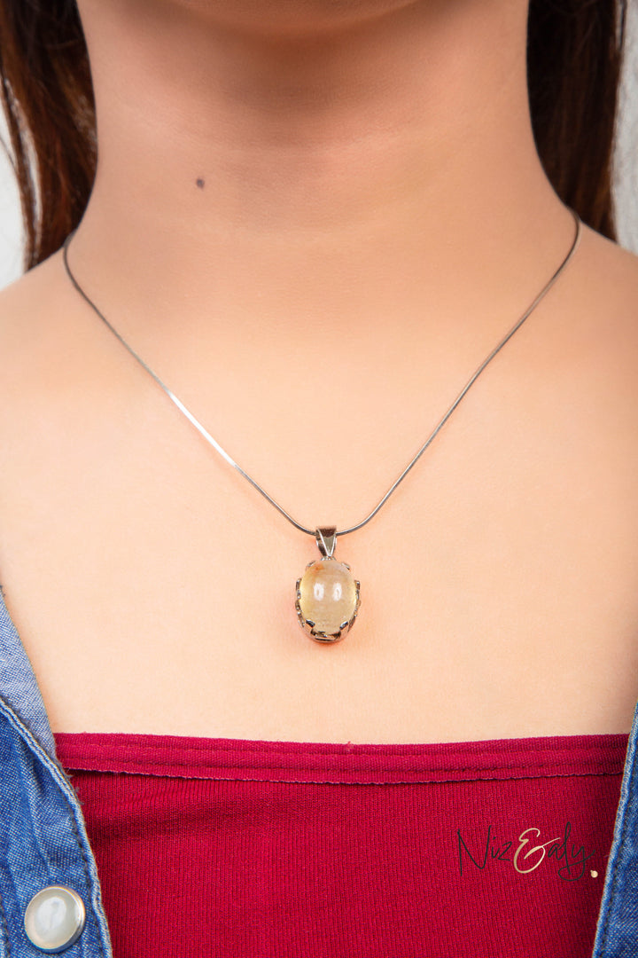 Niz & Aly Raw Citrine Bliss pendant featuring a golden-yellow raw stone in a silver setting worn on a delicate chain