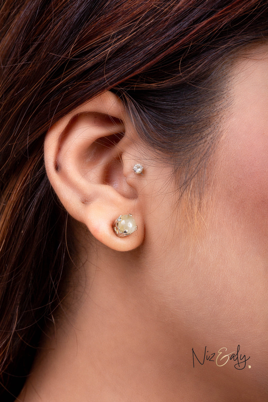 Niz & Aly Raw Citrine Bliss stud earring worn on a woman's earlobe, featuring a rough golden-yellow citrine stone.