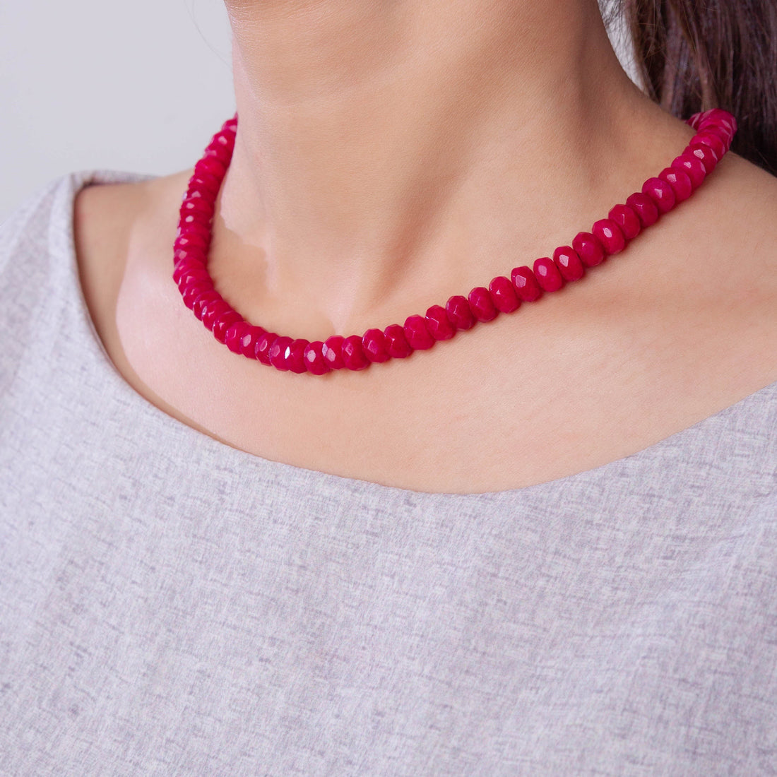 Niz & Aly scarlet red jade bead strand necklace worn around a model's neck, featuring polished, vibrant gemstones.