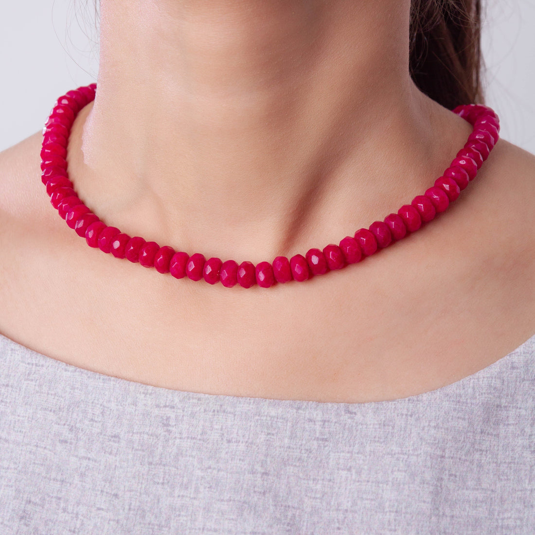 Niz & Aly scarlet red jade beaded necklace worn around a model's neck, featuring polished round gemstone beads.