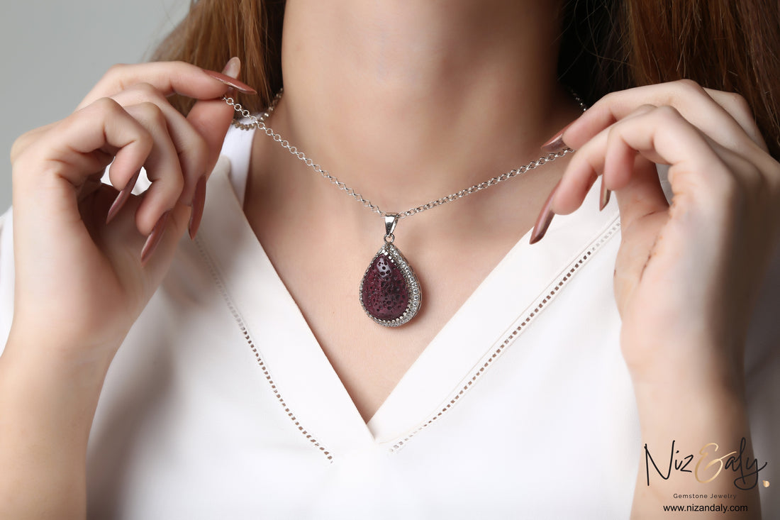Niz & Aly teardrop red lava stone pendant necklace with silver setting worn on a woman's neck