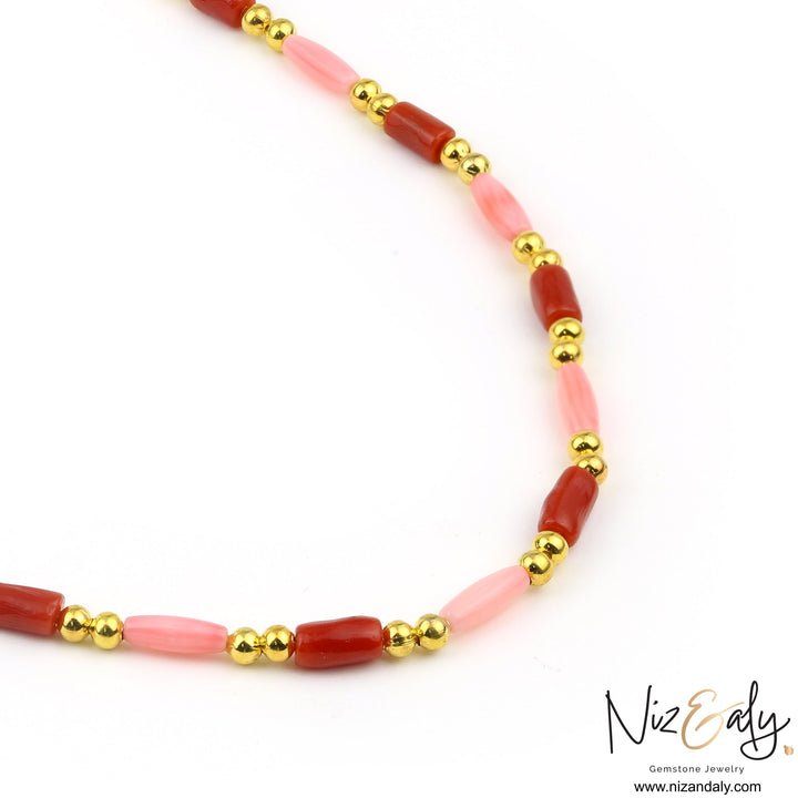 Niz & Aly dainty necklace featuring red and pink rice-shaped coral beads accented with polished round gold beads.