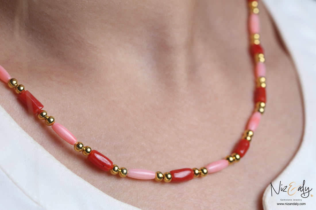 Niz & Aly dainty necklace featuring red and pink rice-shaped natural coral beads accented with polished gold spheres.