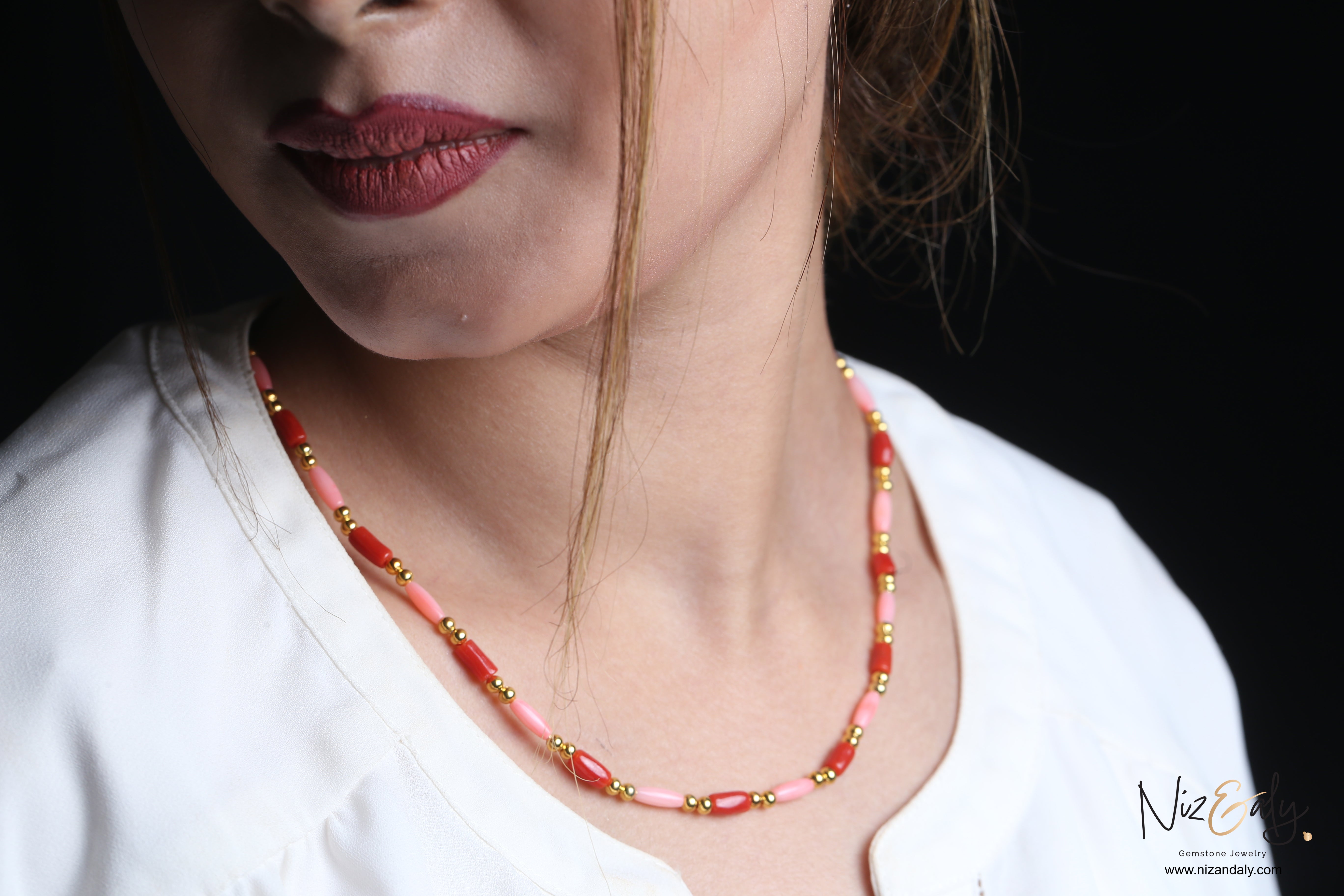 Niz & Aly dainty necklace featuring red and pink rice-shaped coral beads accented with small polished gold spheres
