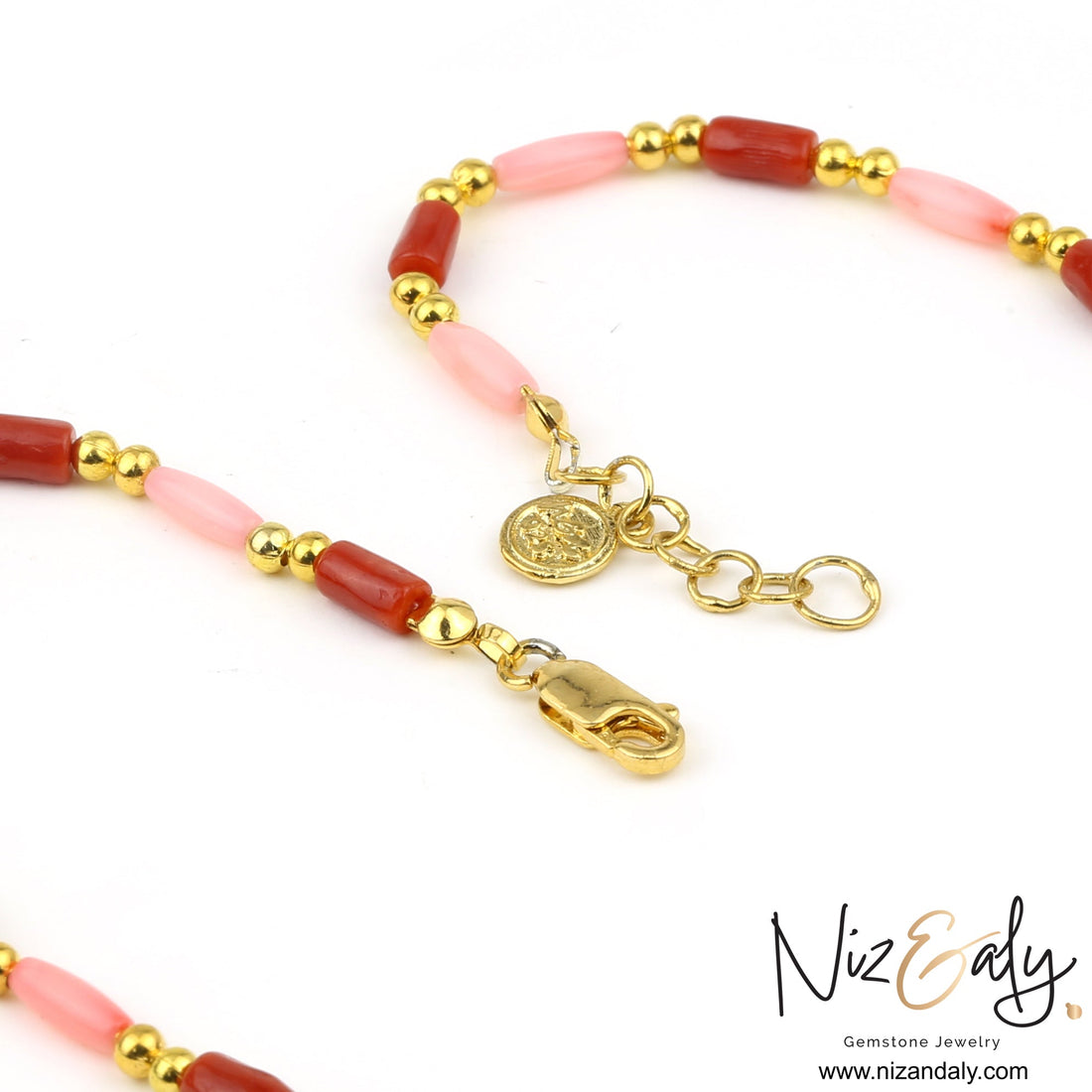 Niz & Aly dainty necklace featuring red and pink rice-shaped coral beads accented with polished gold beads and a charm.