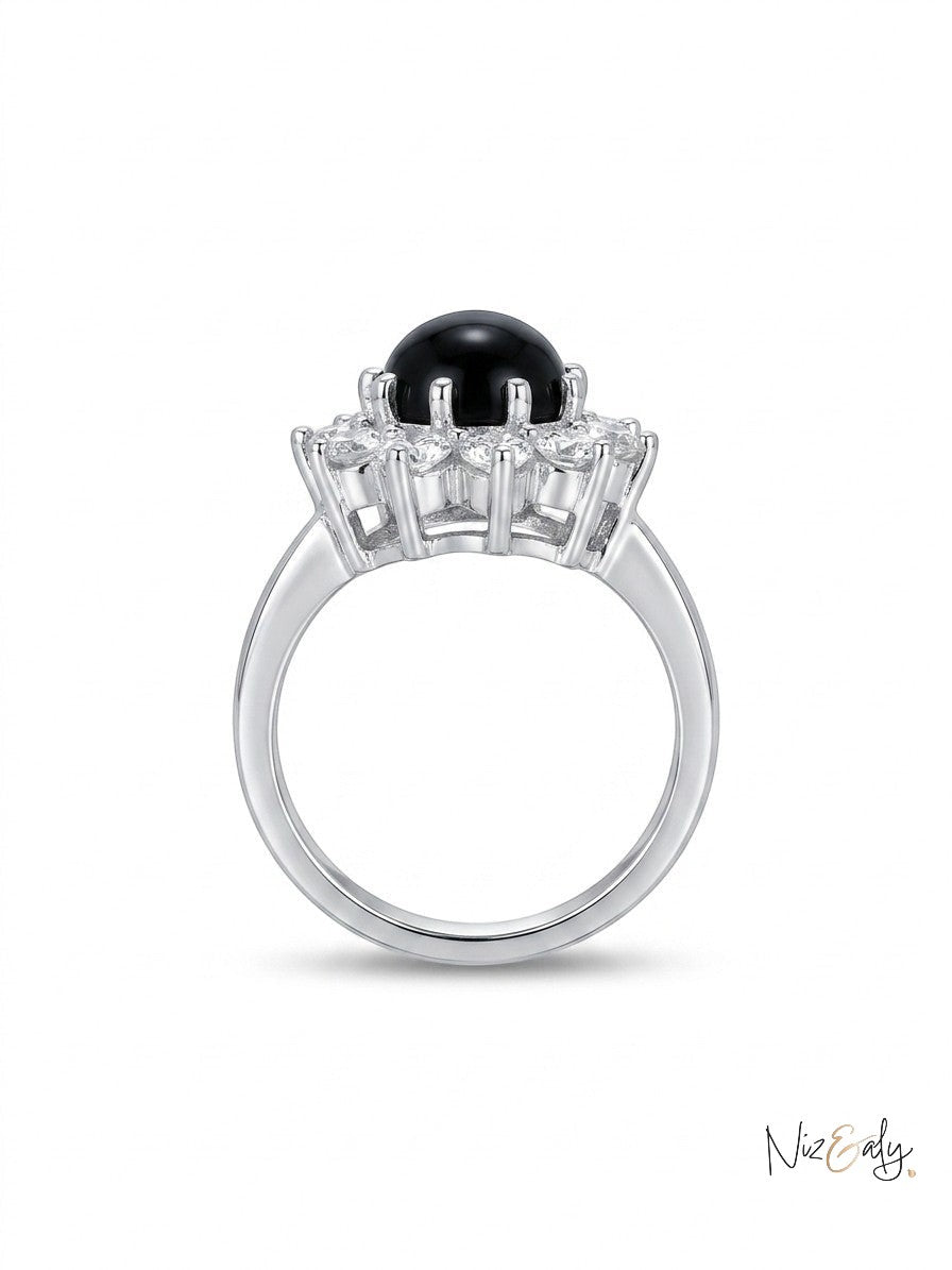 Niz & Aly round black onyx statement ring with a polished gemstone and halo of clear stones on a silver band.