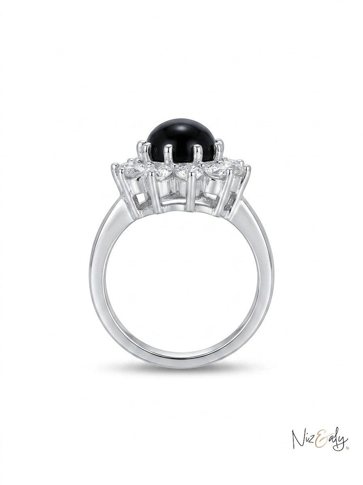 Niz & Aly round black onyx statement ring with a polished gemstone and halo of clear stones on a silver band.