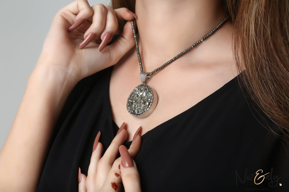 Niz & Aly round pyrite pendant necklace with faceted beads worn by a woman in a black top