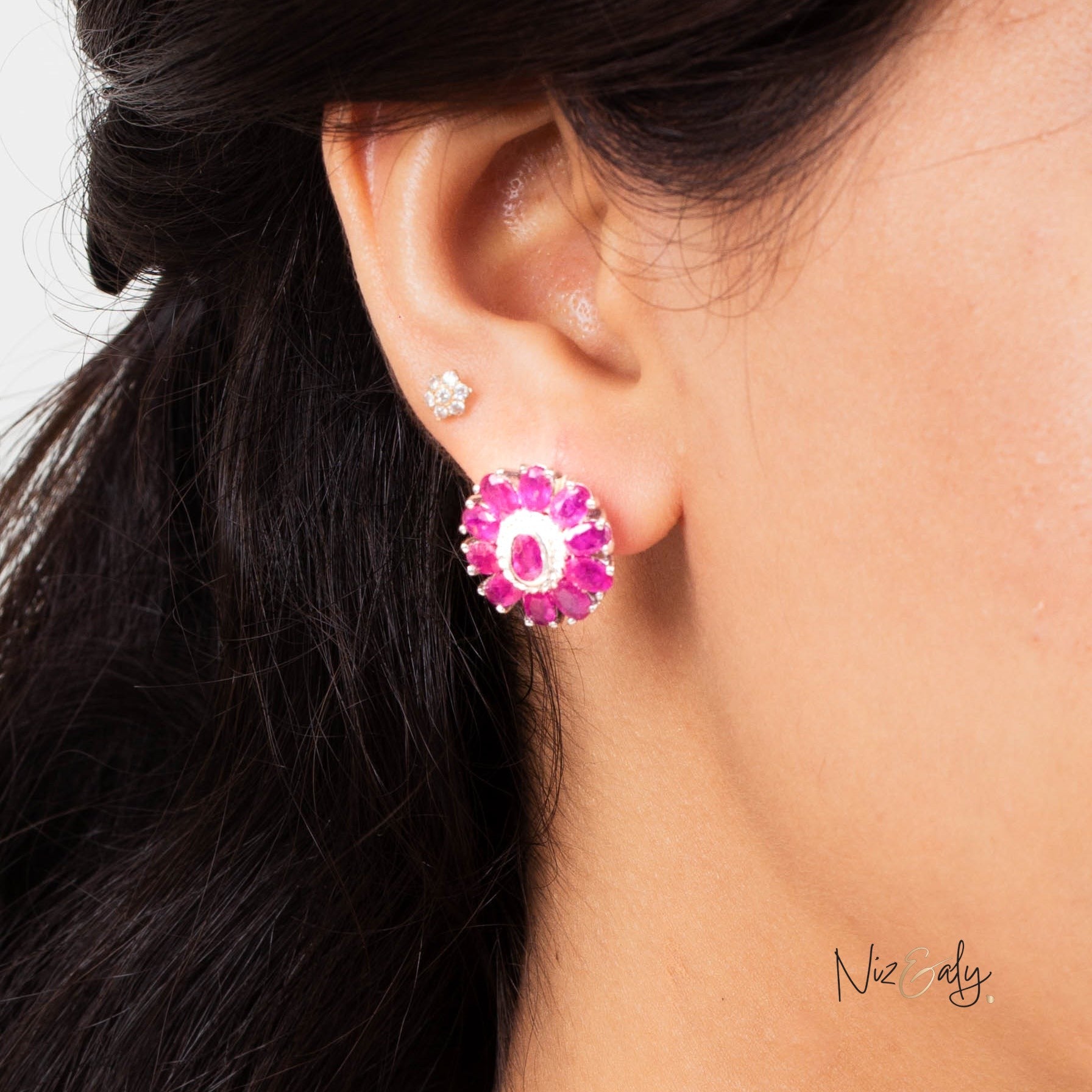 Niz & Aly Nothing But Rubies earring featuring a cluster of vibrant red rubies worn on a woman's earlobe