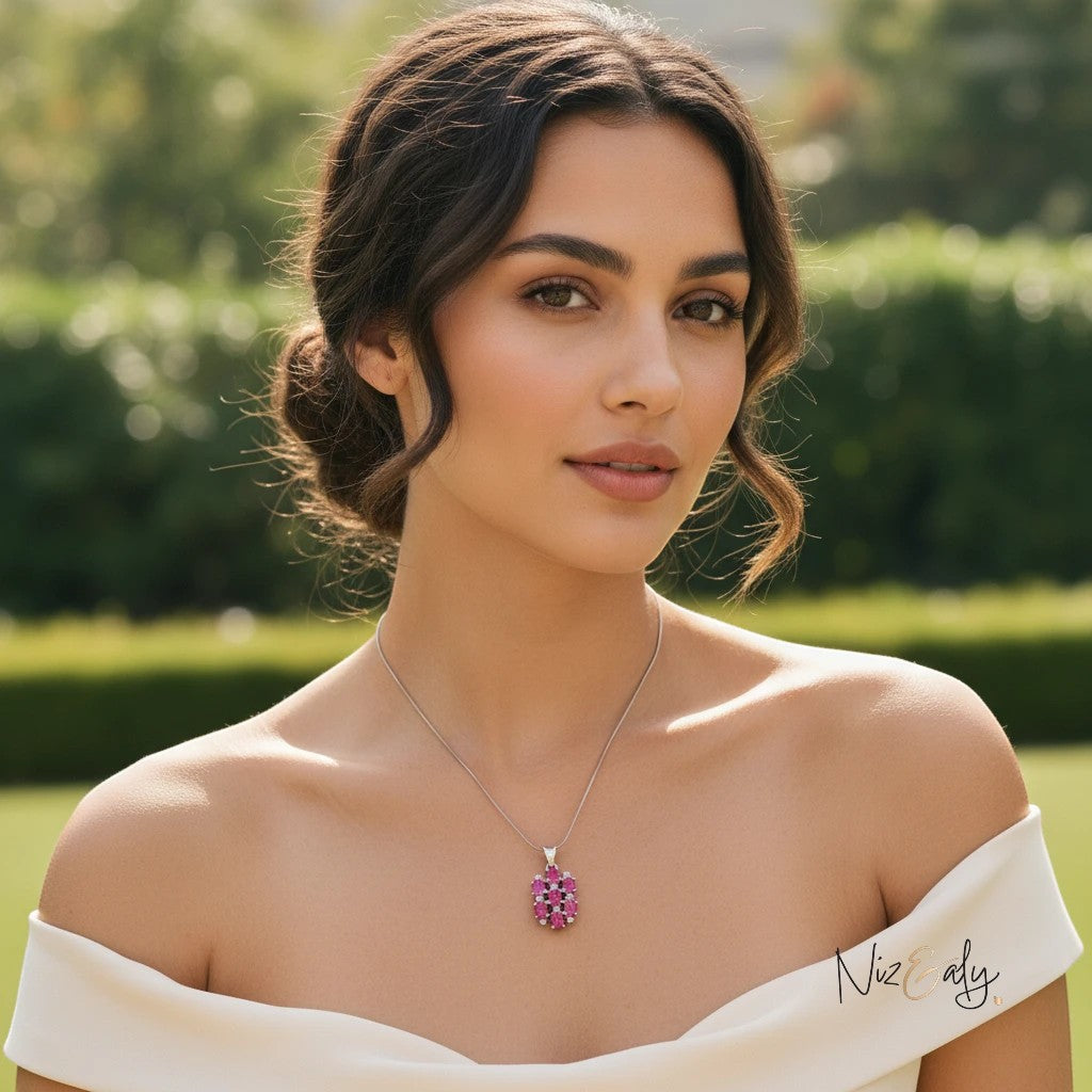 Niz & Aly pendant featuring seven high-quality red rubies in a cluster setting worn by a woman in a white dress.