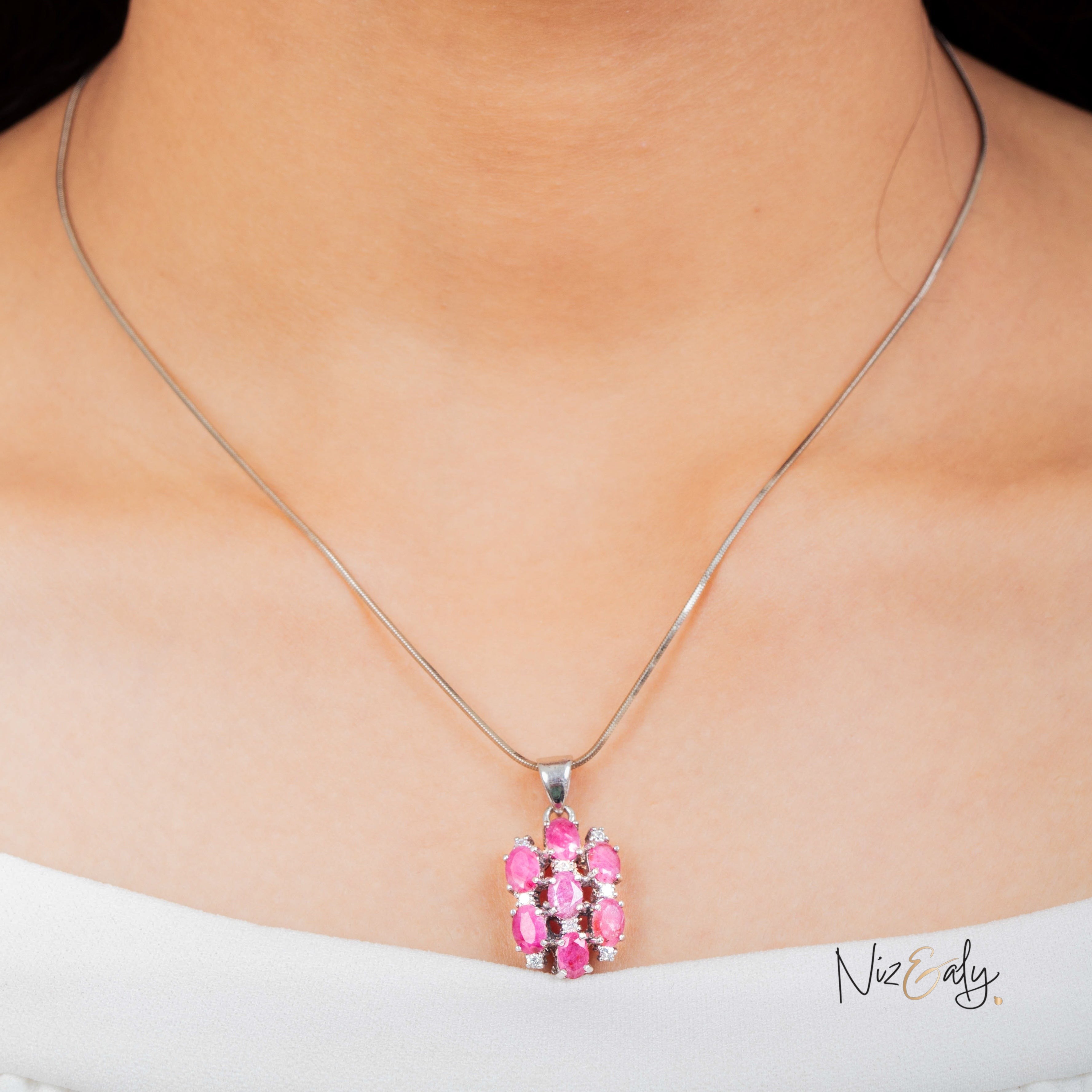Niz & Aly cluster pendant featuring seven high-quality red rubies set in silver, worn on a delicate chain.