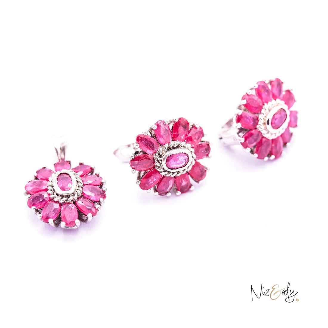 Niz & Aly Nothing But Rubies jewelry set featuring three floral-shaped pieces with deep red natural rubies in silver