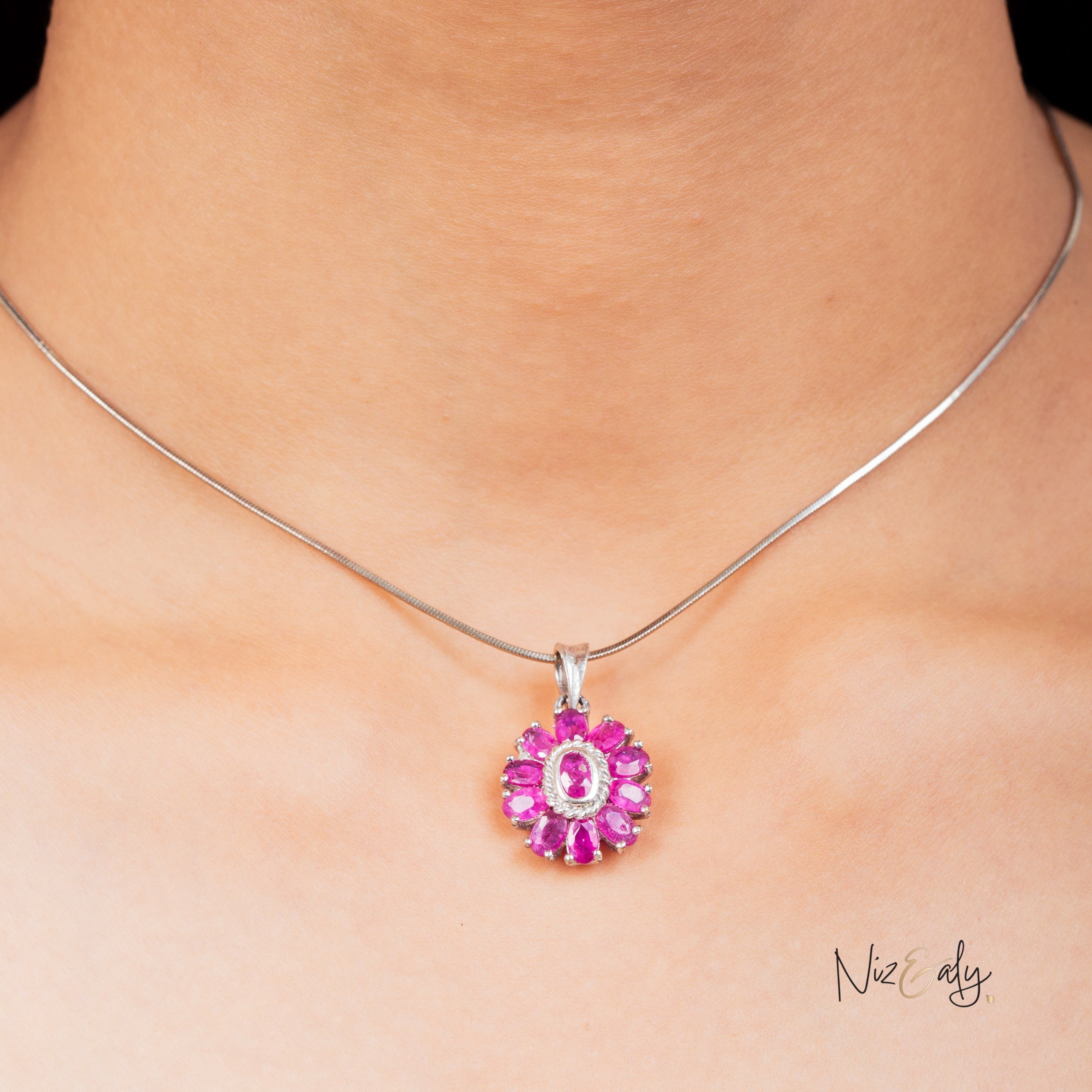 Niz & Aly Nothing But Rubies necklace featuring 33 vibrant red rubies in a floral silver setting on a model