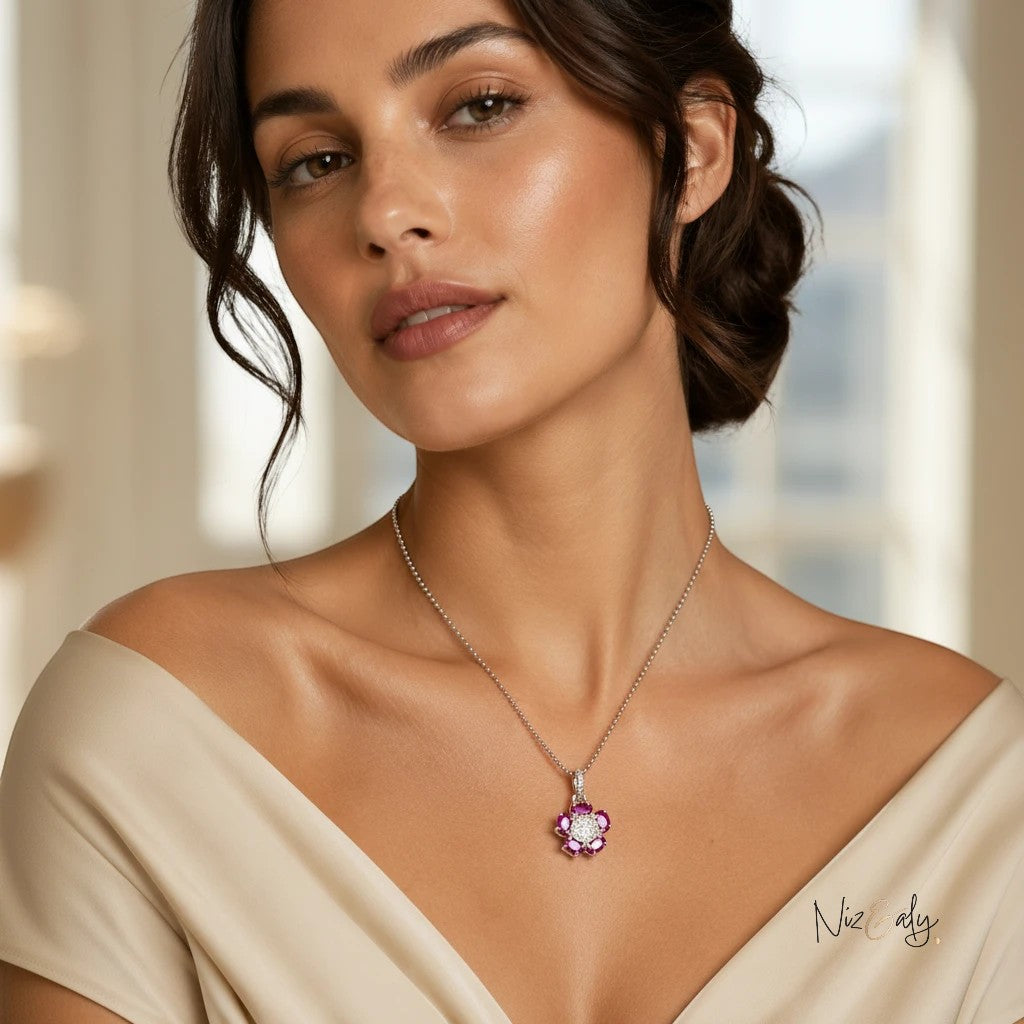 Niz & Aly flower pendant featuring five red rubies and an intricate silver center worn by a woman in a beige dress.