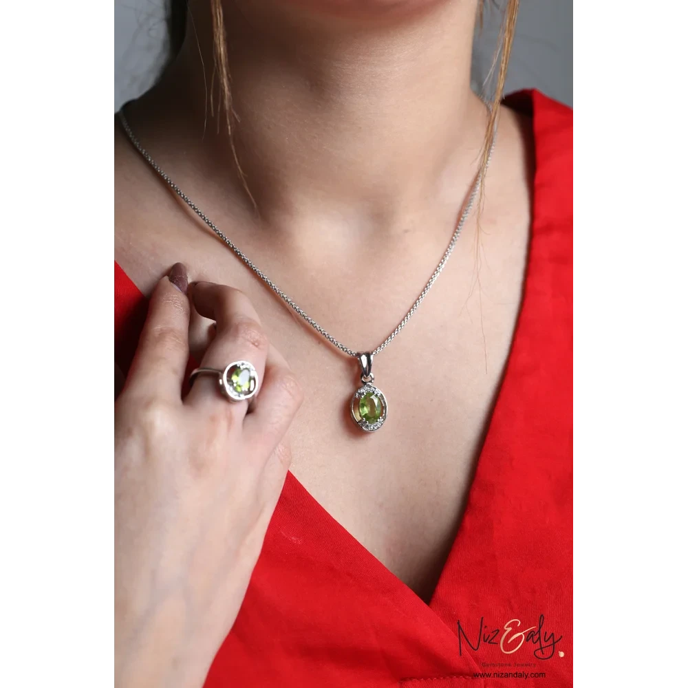 Niz & Aly Sage Dawn oval Arizona peridot pendant and ring set in silver worn by a woman in a red top.
