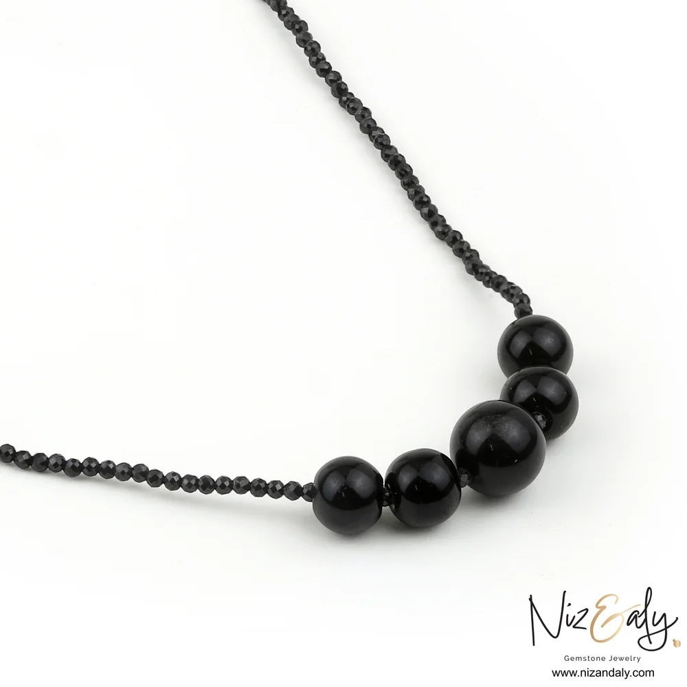 Niz & Aly dainty bar necklace featuring smooth black Shungite stones and faceted Onyx beads on a delicate chain.