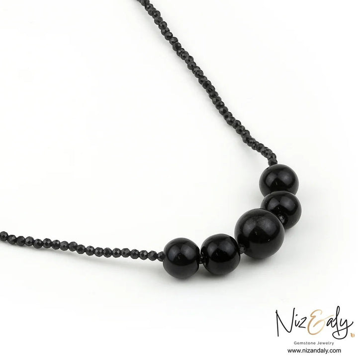 Niz & Aly dainty bar necklace featuring smooth black Shungite stones and faceted Onyx beads on a delicate chain.