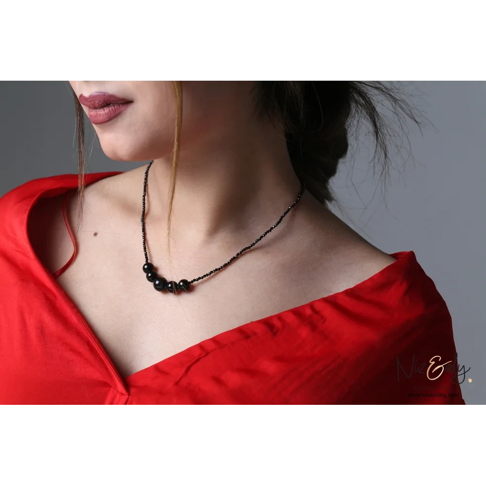 Niz & Aly dainty shungite bar necklace with faceted onyx beads and sterling silver accents worn by a woman