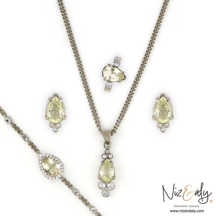 Niz & Aly Silver Moonlight teardrop clear quartz pendant set with matching earrings, ring, and bracelet in silver.