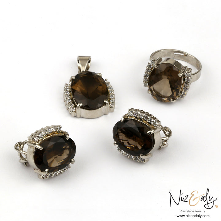 Niz & Aly smoky quartz jewelry set featuring a pendant, ring, and earrings with faceted brown gemstones and crystals.