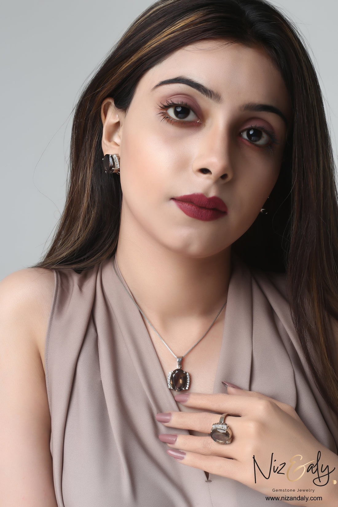 Niz & Aly smoky quartz pendant set with matching earrings and ring worn by a woman in a beige top