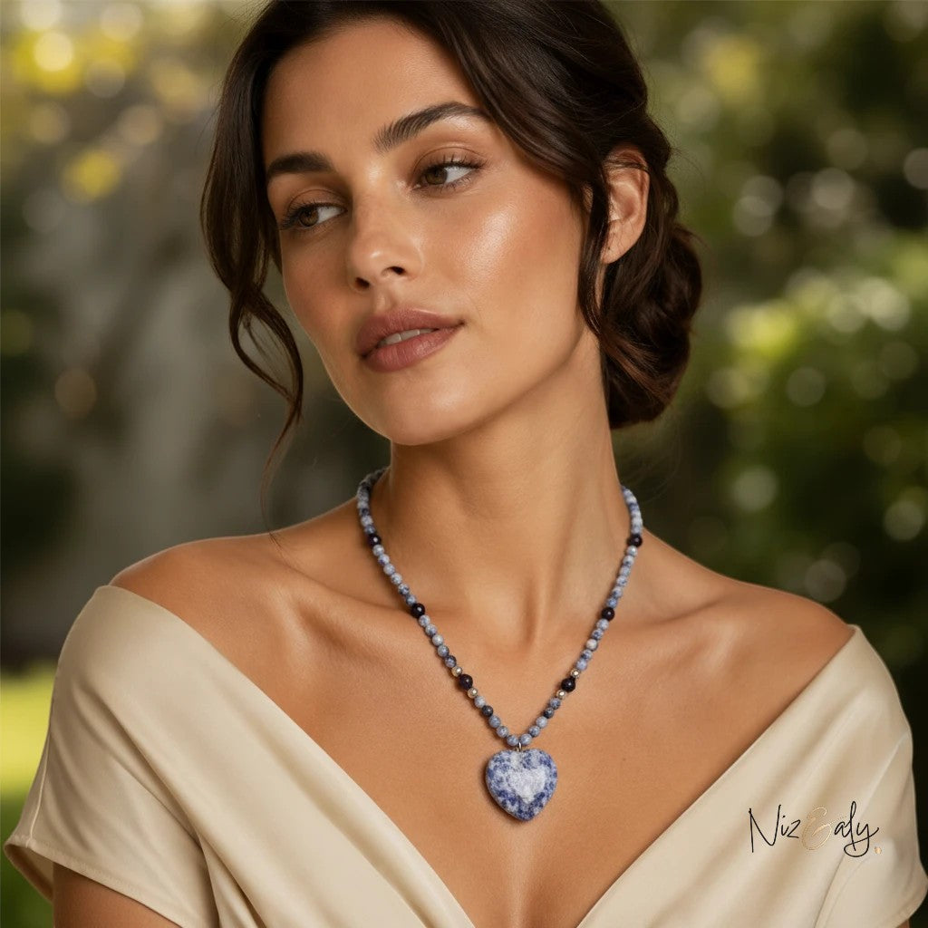 Niz & Aly sodalite heart pendant necklace with blue stone beads worn by a woman in a cream off-shoulder top.