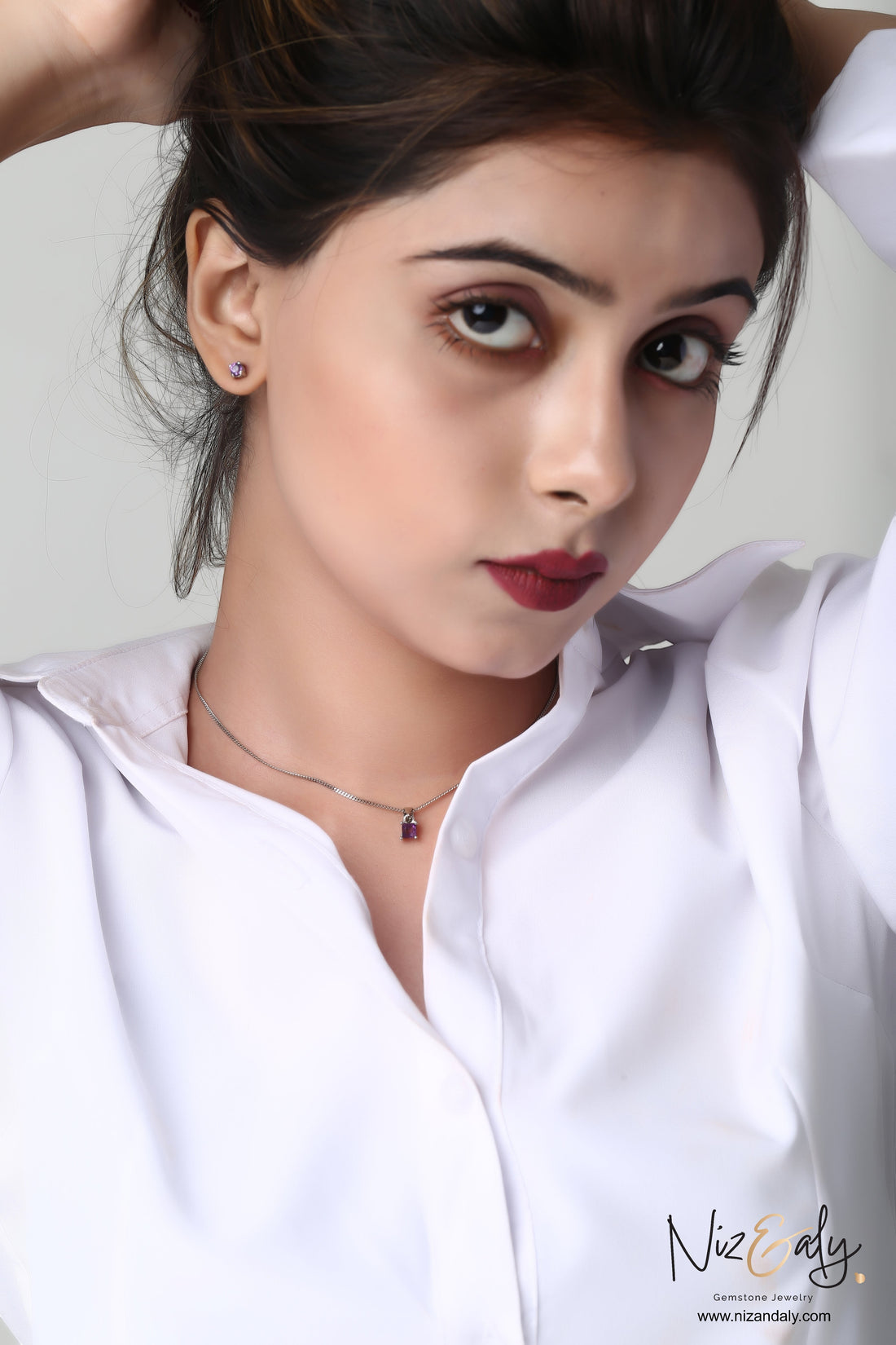 Niz & Aly dainty square amethyst necklace and stud earring set worn by a woman in a white shirt