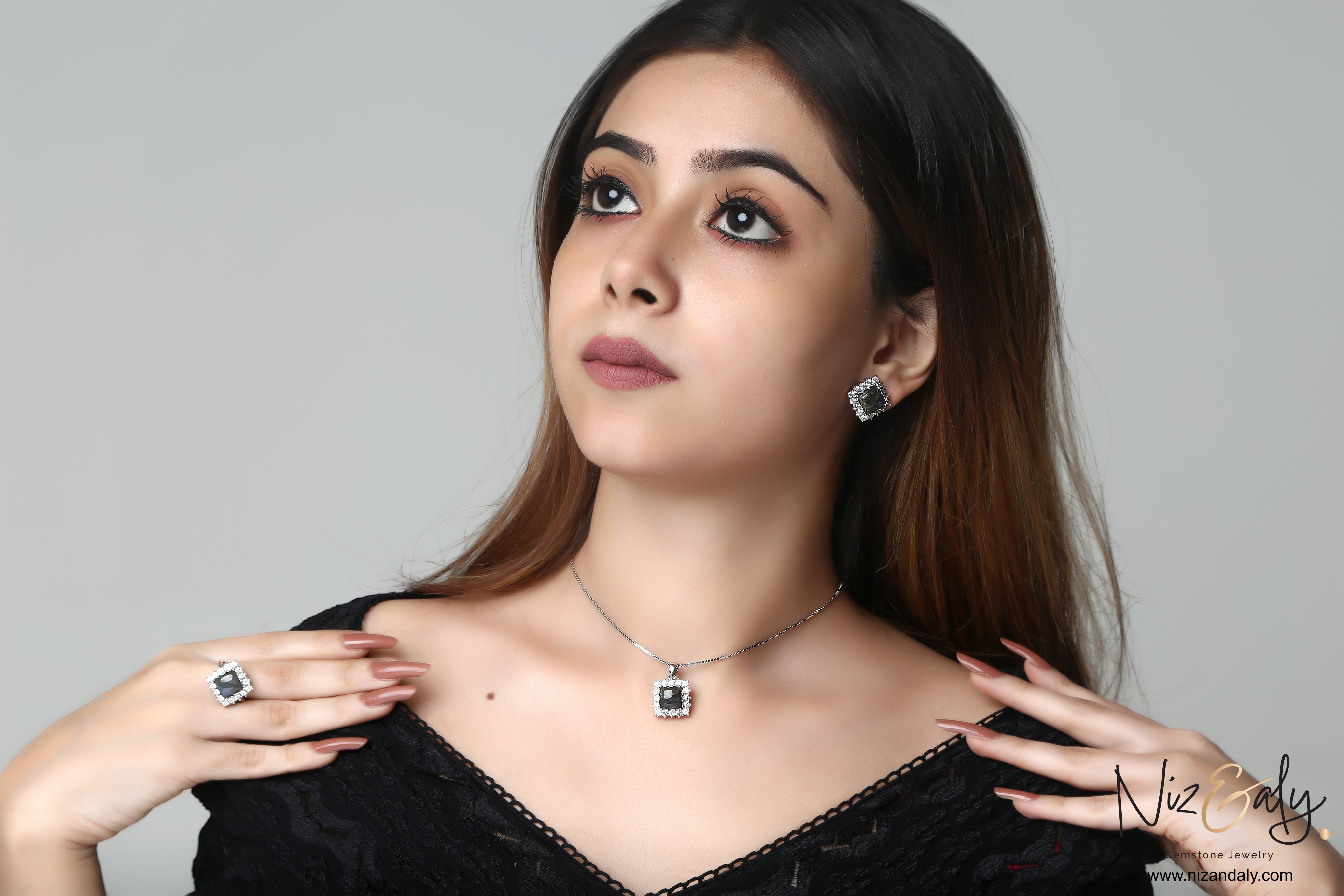 Niz & Aly square labradorite pendant and earring set with blue fire flash worn by a woman in a black top.