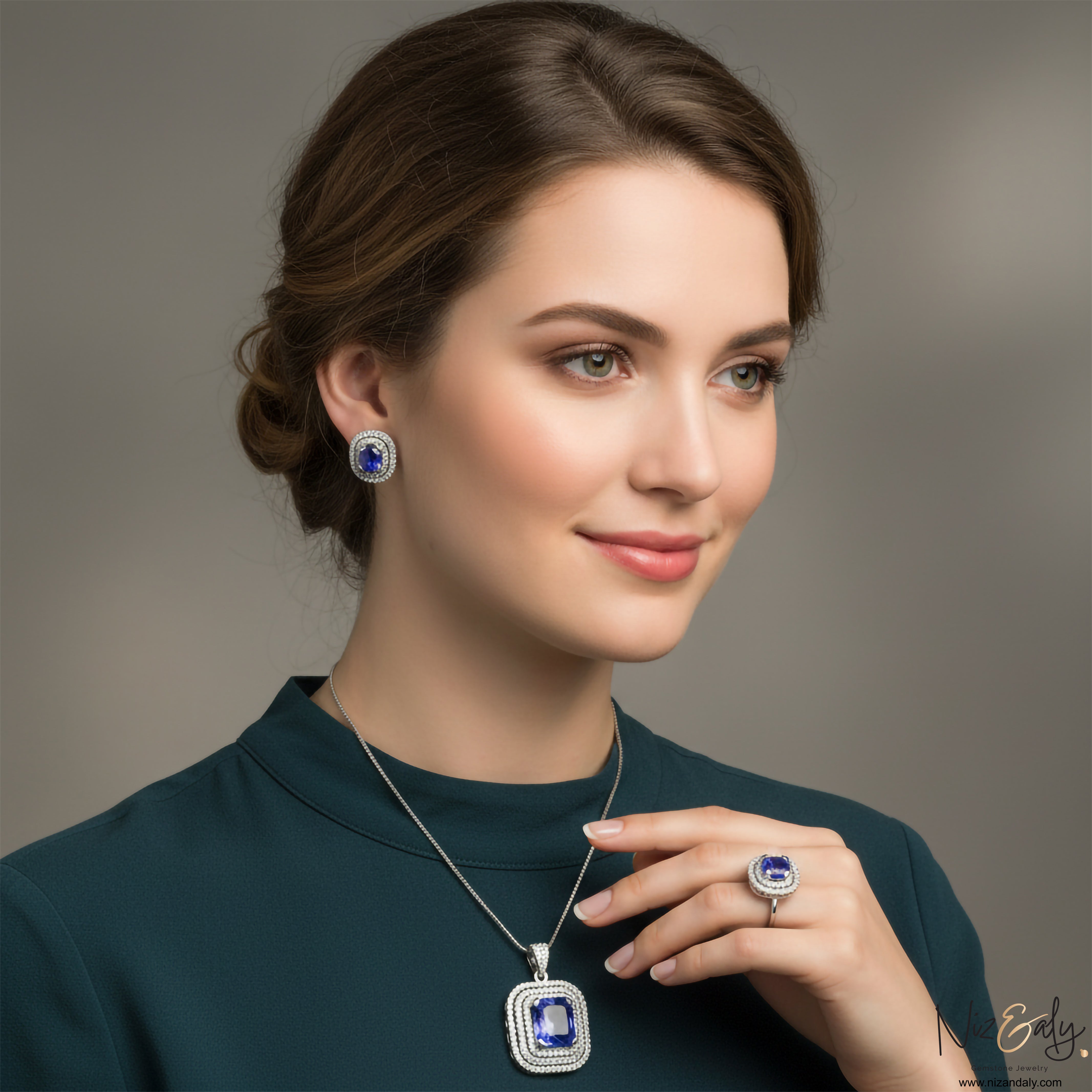 Niz & Aly lavender blue tanzanite jewelry set featuring a pendant, earrings, and ring worn by a woman in a green top.