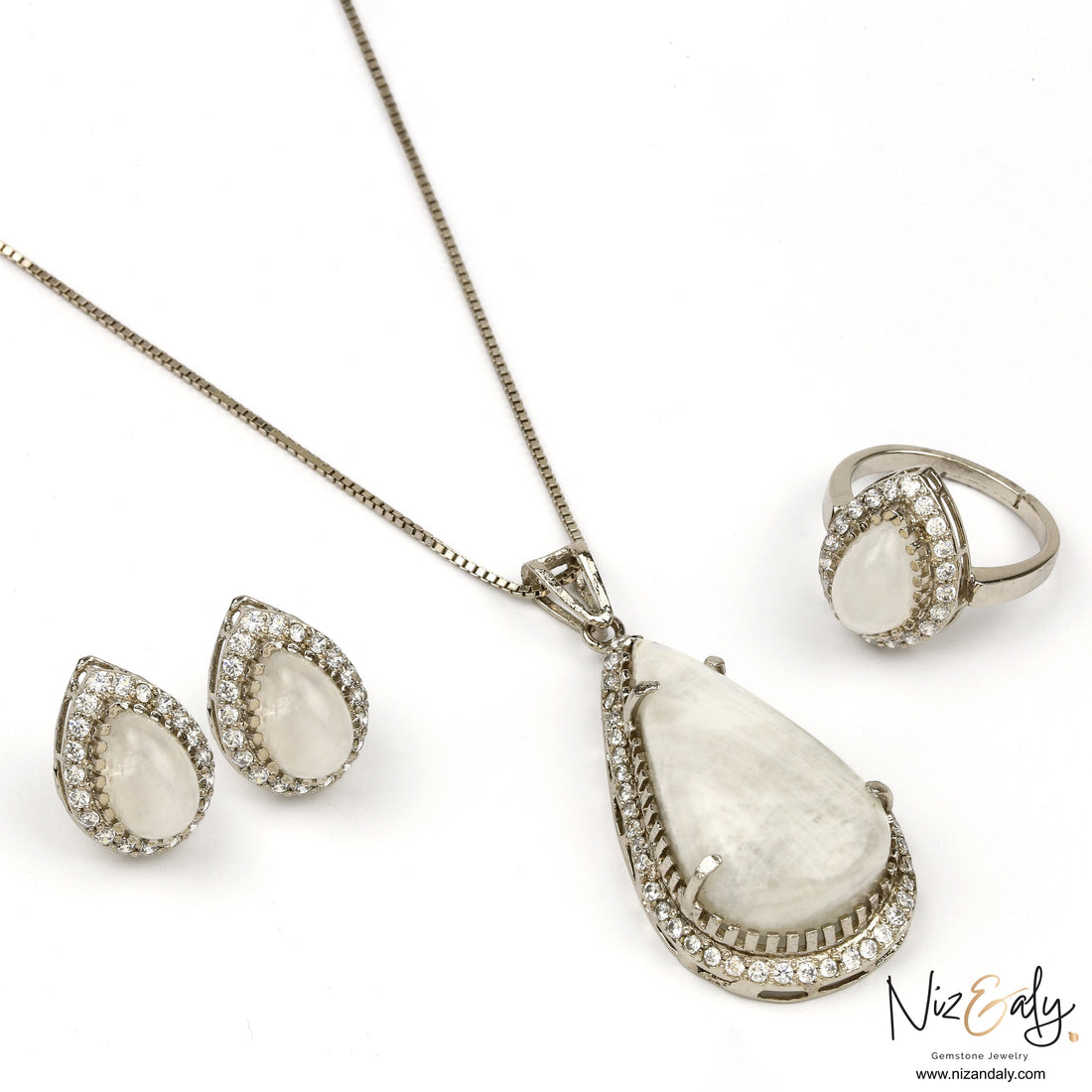 Niz & Aly teardrop moonstone jewelry set with blue flash, featuring a pendant, earrings, and ring in silver setting.