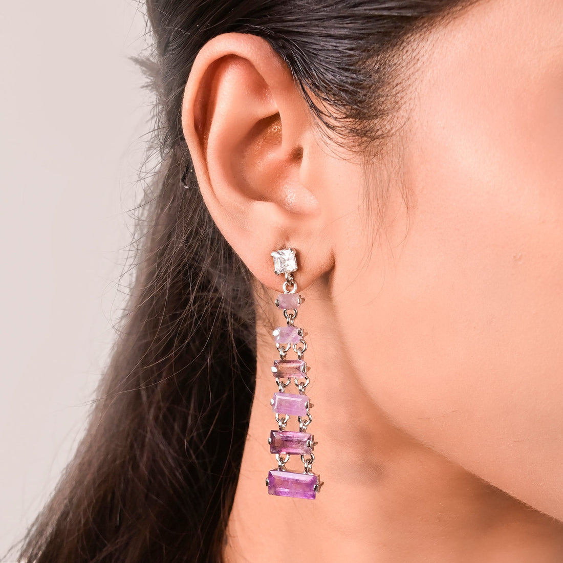 Niz & Aly tiered rectangle amethyst drop earrings featuring layered purple gemstones on a model's ear