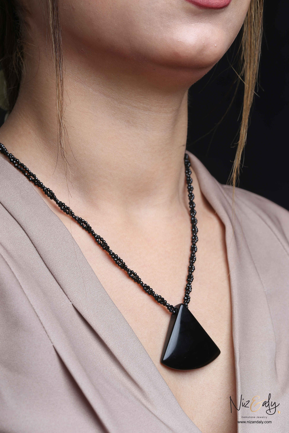 Niz & Aly Agate Eclipse necklace featuring a smooth triangular black agate pendant on a twisted black onyx bead chain.