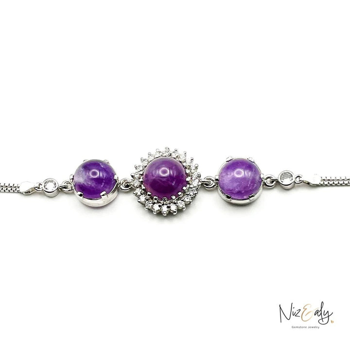 Niz & Aly triple amethyst bracelet featuring three purple cabochon gemstones set in silver with sparkling accents.