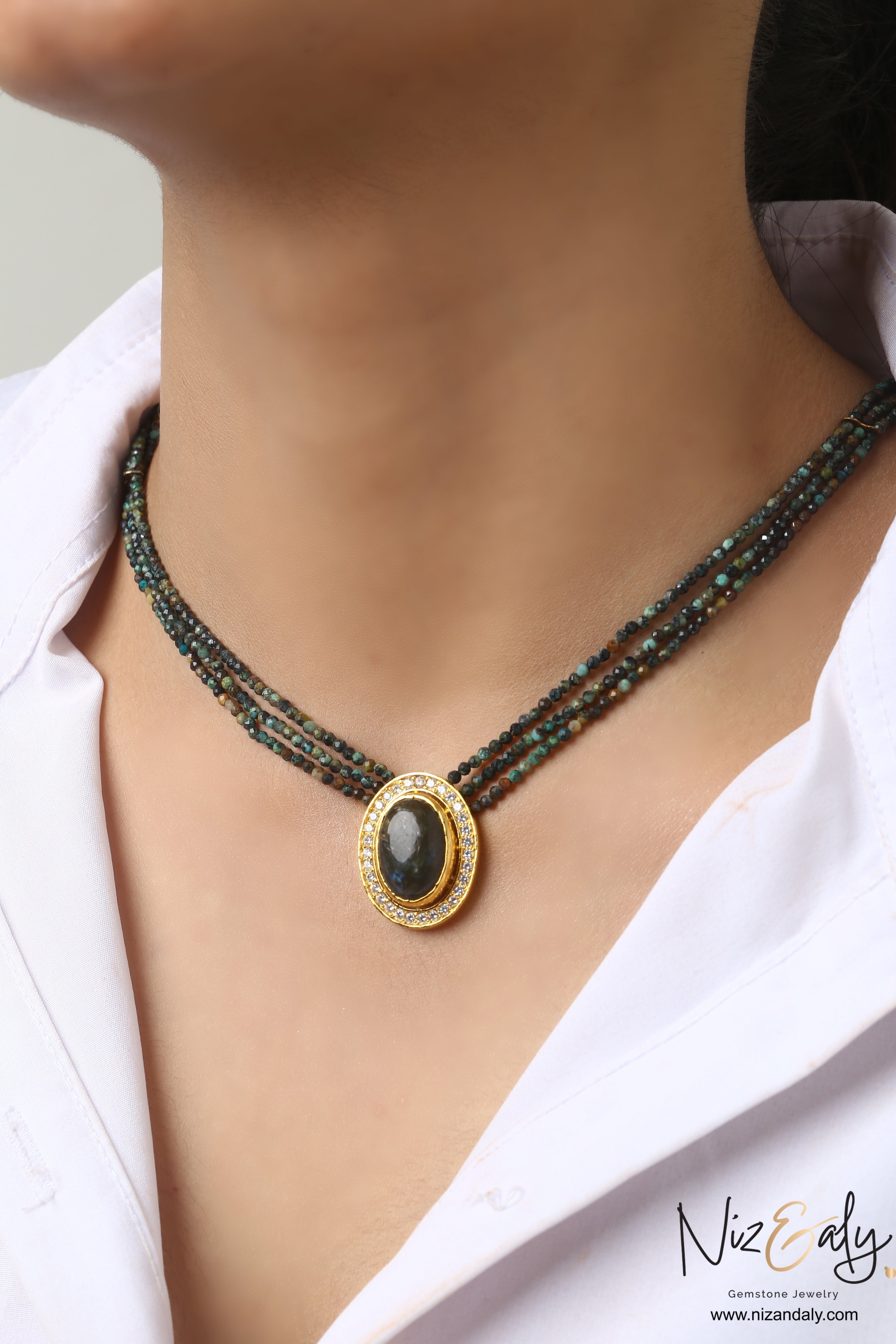Niz & Aly triple strand necklace with earth-toned faceted gemstone beads and an oval center stone in a crystal halo.