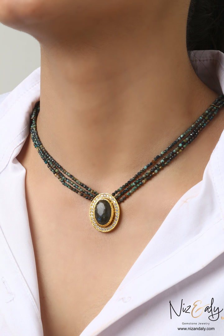 Niz & Aly triple strand necklace with earth-toned faceted gemstone beads and an oval center stone in a crystal halo.