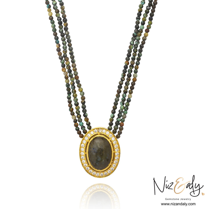 Niz & Aly triple strand necklace with earth-toned faceted gemstone beads and an oval crystal-framed pendant