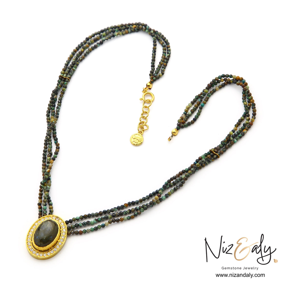 Niz & Aly triple strand necklace with earth-toned faceted gemstone beads and an oval crystal-framed pendant in gold.