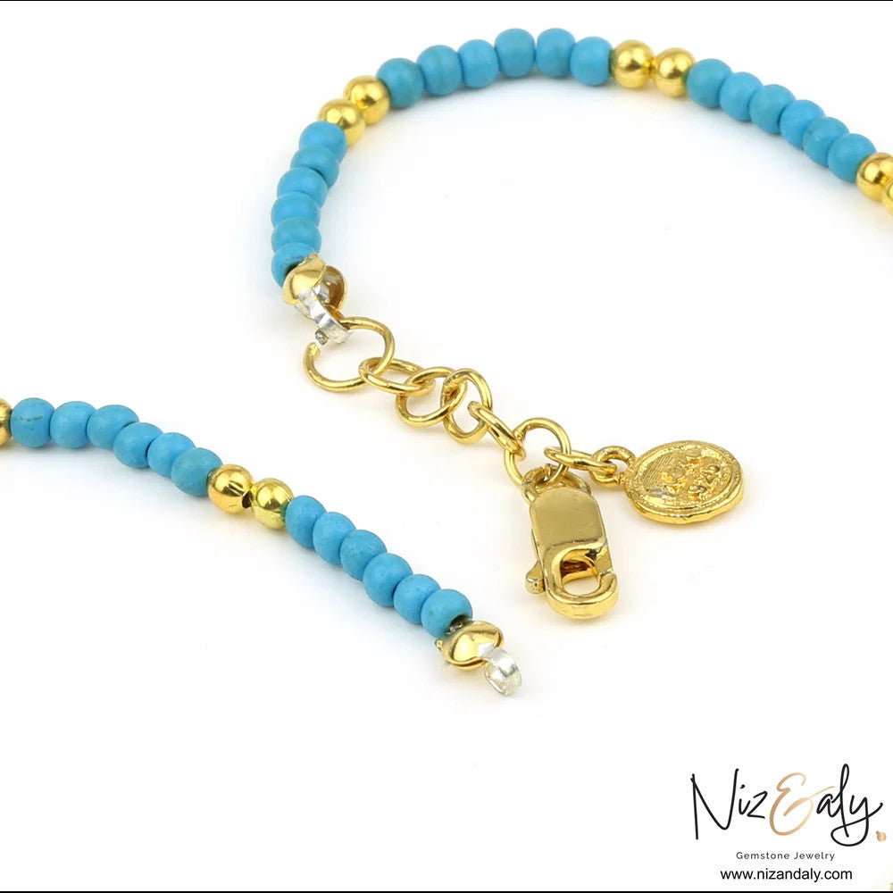 Niz & Aly turquoise beaded necklace with gold-tone spacers, lobster clasp, and a small round coin charm.