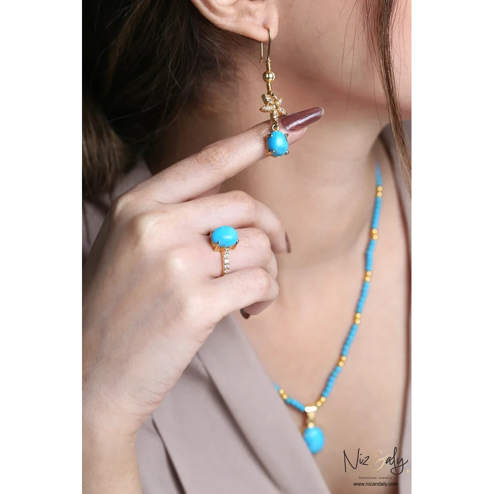 Niz & Aly turquoise gemstone necklace, drop earring, and ring set with gold-tone metal and crystal accents on a model