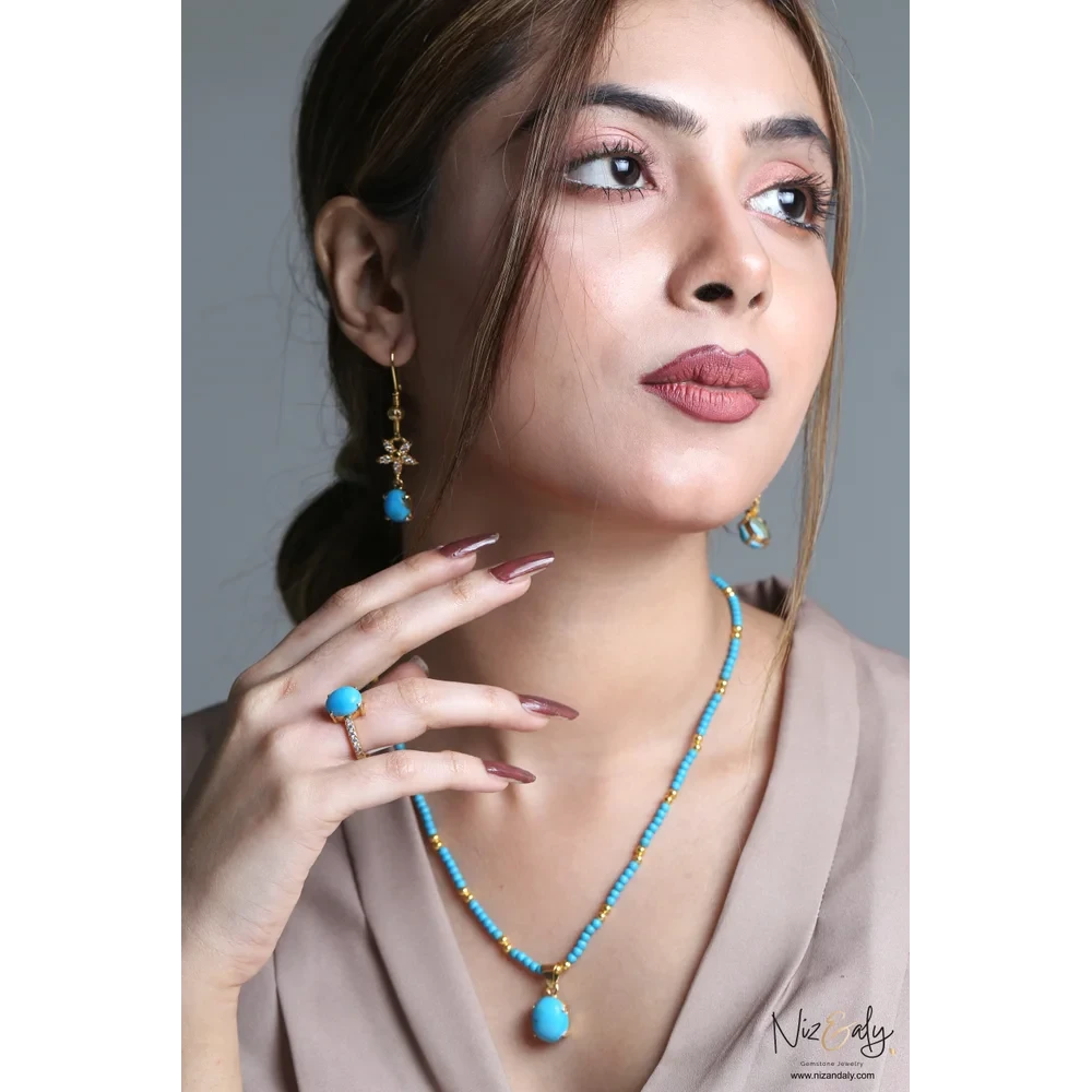 Niz & Aly three-piece jewelry set featuring a turquoise gemstone necklace, drop earrings, and ring on a model.