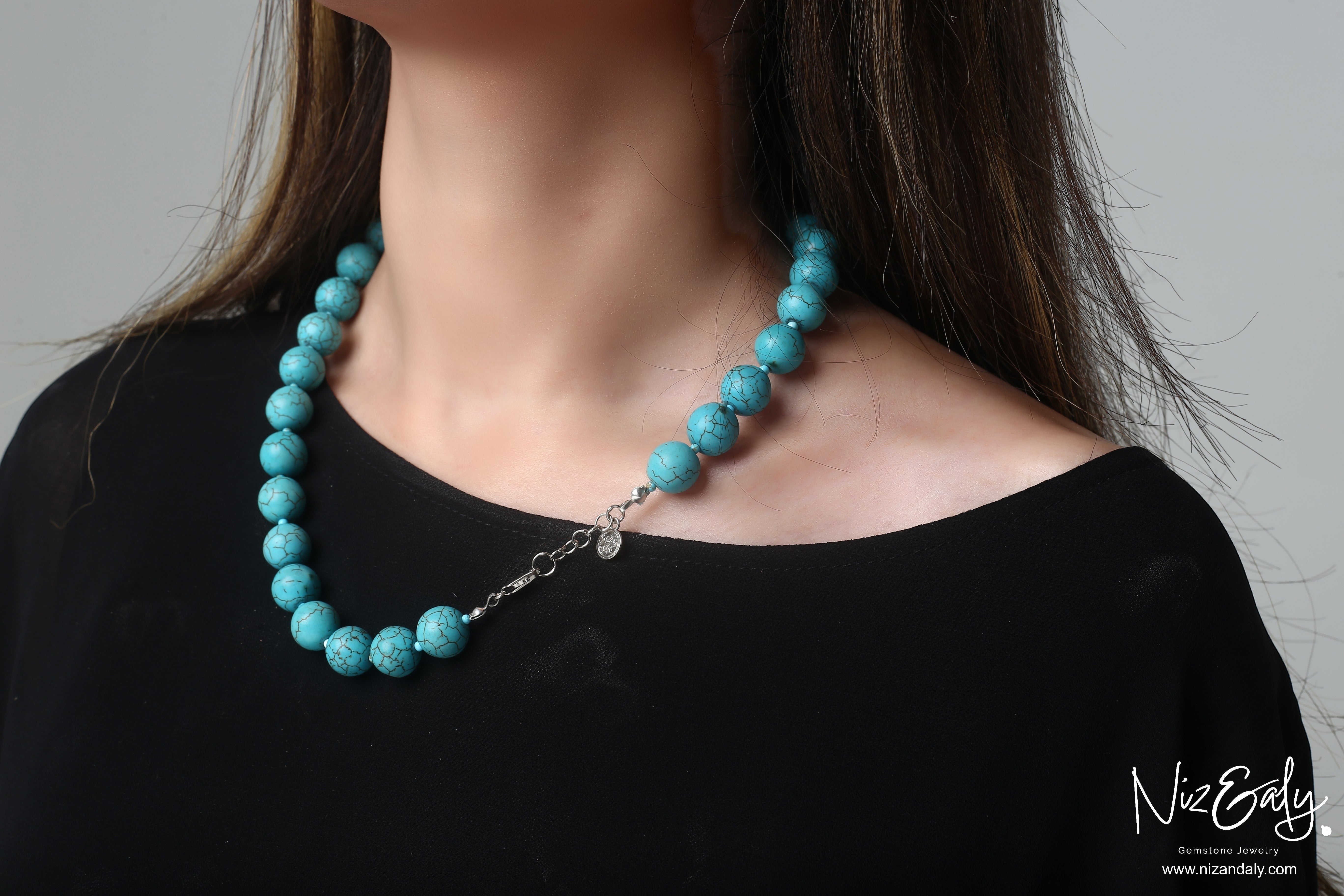 Niz & Aly turquoise howlite beaded necklace with marbled sky-blue stones worn on a model in a black top.