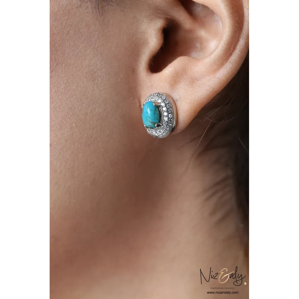 Niz & Aly oval turquoise stud earring with a sparkling cubic zirconia halo worn on a model's ear