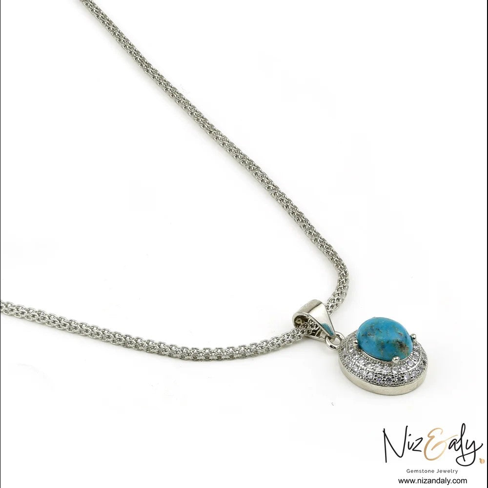 Niz & Aly necklace featuring an oval turquoise gemstone surrounded by a sparkling cubic zirconia halo on a silver chain