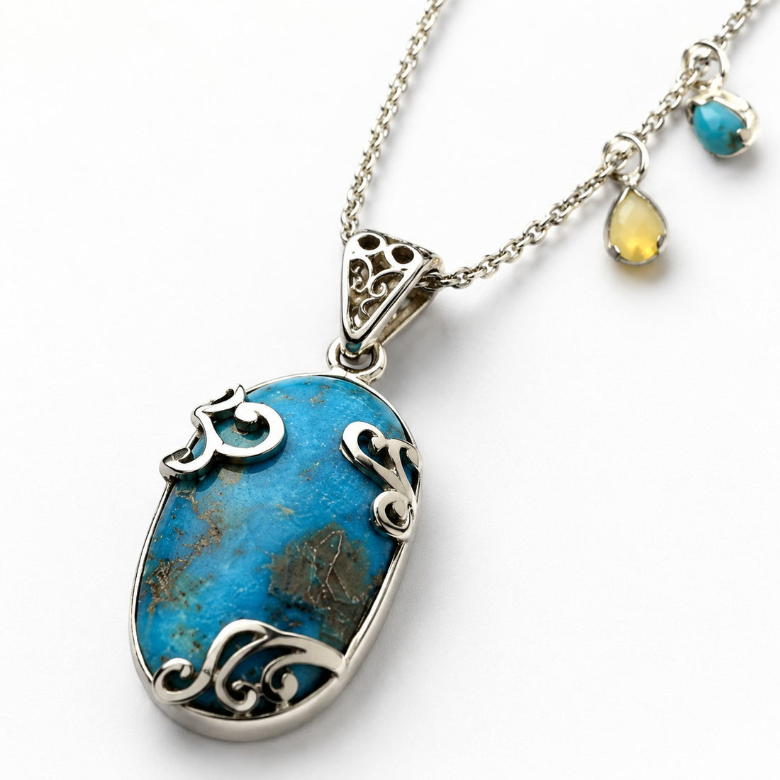 Niz & Aly turquoise pendant necklace featuring an oval gemstone in an ornate silver setting on a delicate chain.