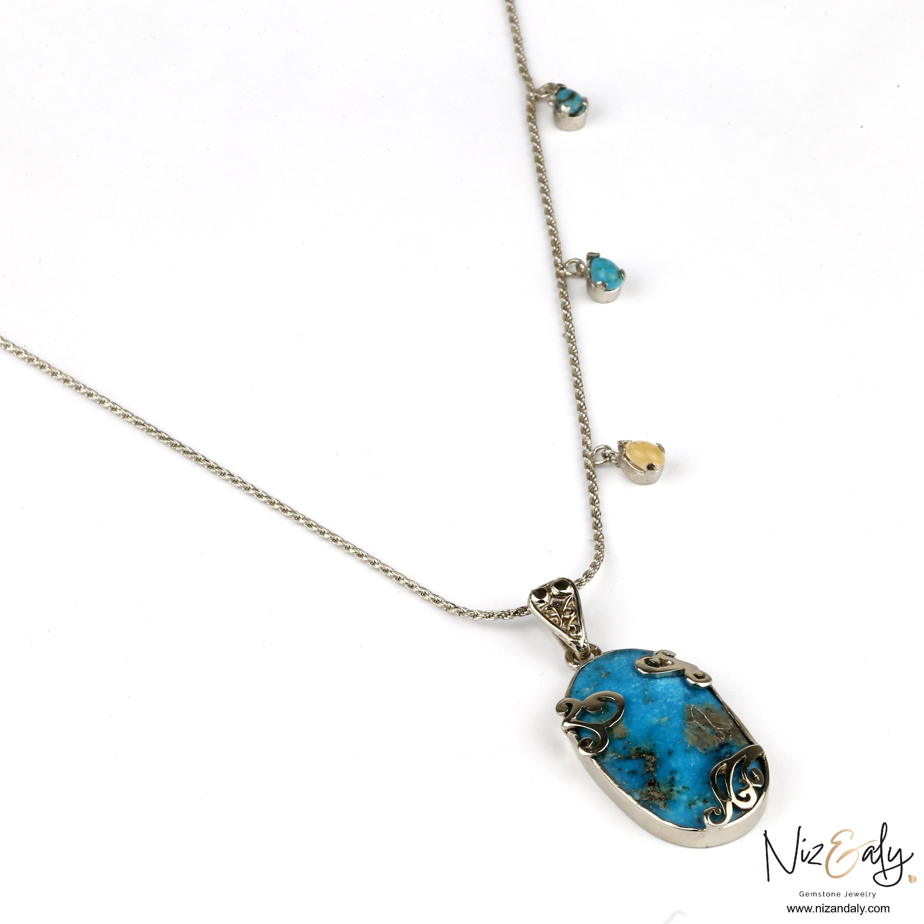 Niz & Aly turquoise pendant necklace with silver filigree detail and small gemstone accents on a delicate chain.