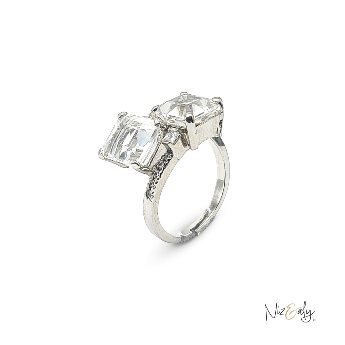 Niz & Aly twin clear quartz ring featuring two radiant stones set in a polished silver band on a white background.