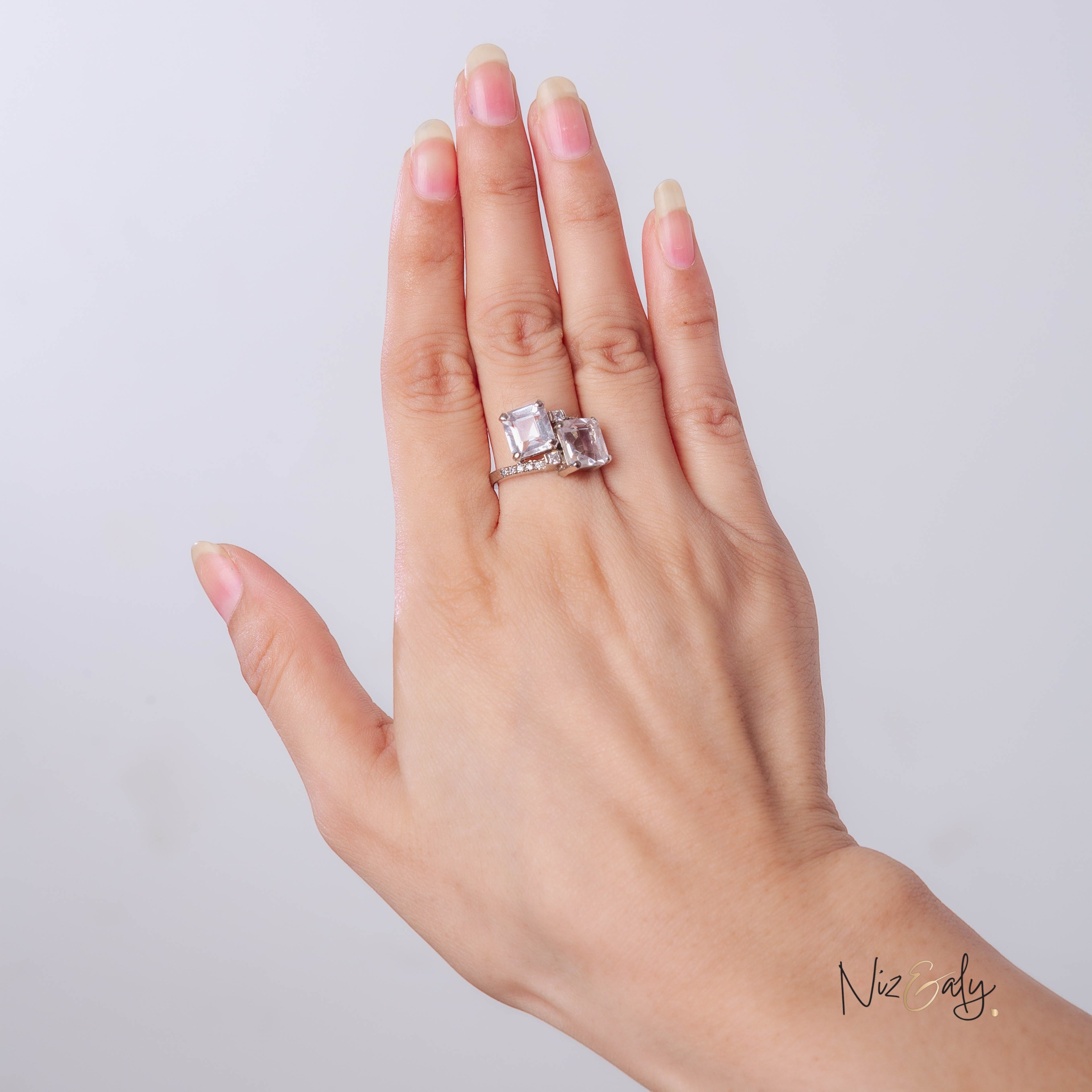 Niz & Aly twin clear quartz ring with two rectangular stones set in a polished silver band on a woman's finger