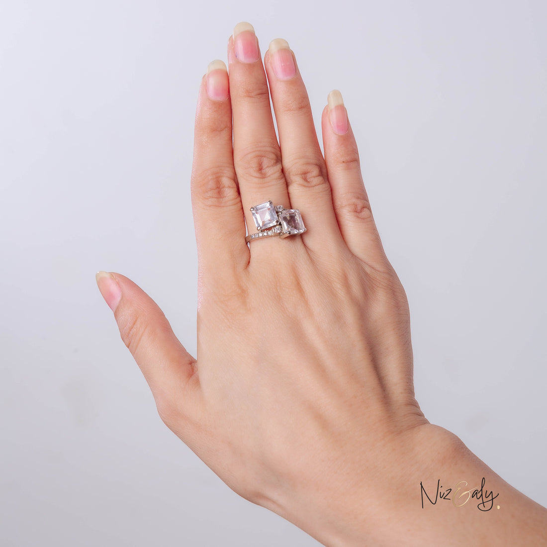 Niz & Aly twin clear quartz ring with two rectangular stones set in a polished silver band on a woman's finger